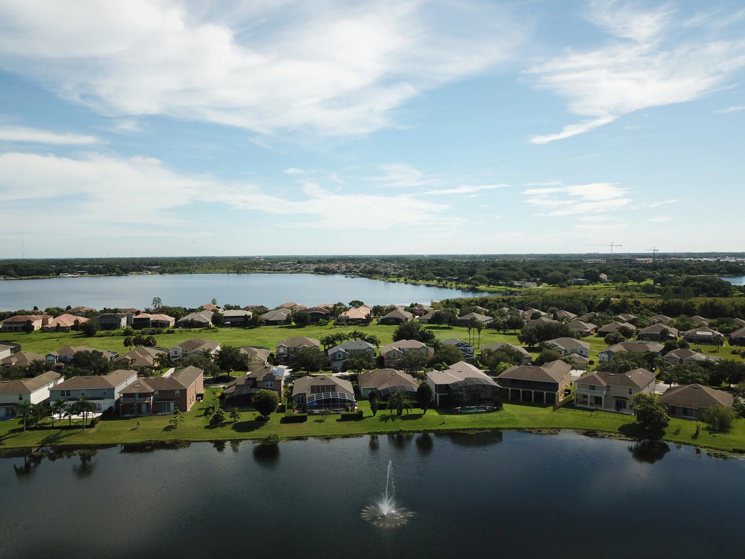Aerial view of lakefront homes, a fountain and a larger lake in the Horizon West area of Winter Garden, Florida